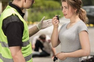 A woman assisted in using a breathalyzer on a DUI checkpoint.