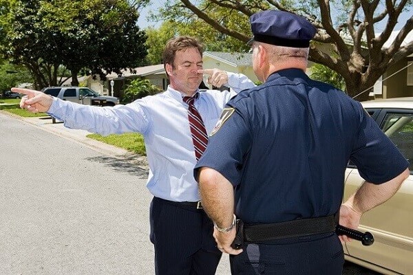 A field officer asking a driver to complete a field sobriety test.