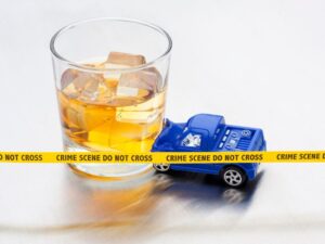 An image of a drink and a toy car representing DUI in Denver.